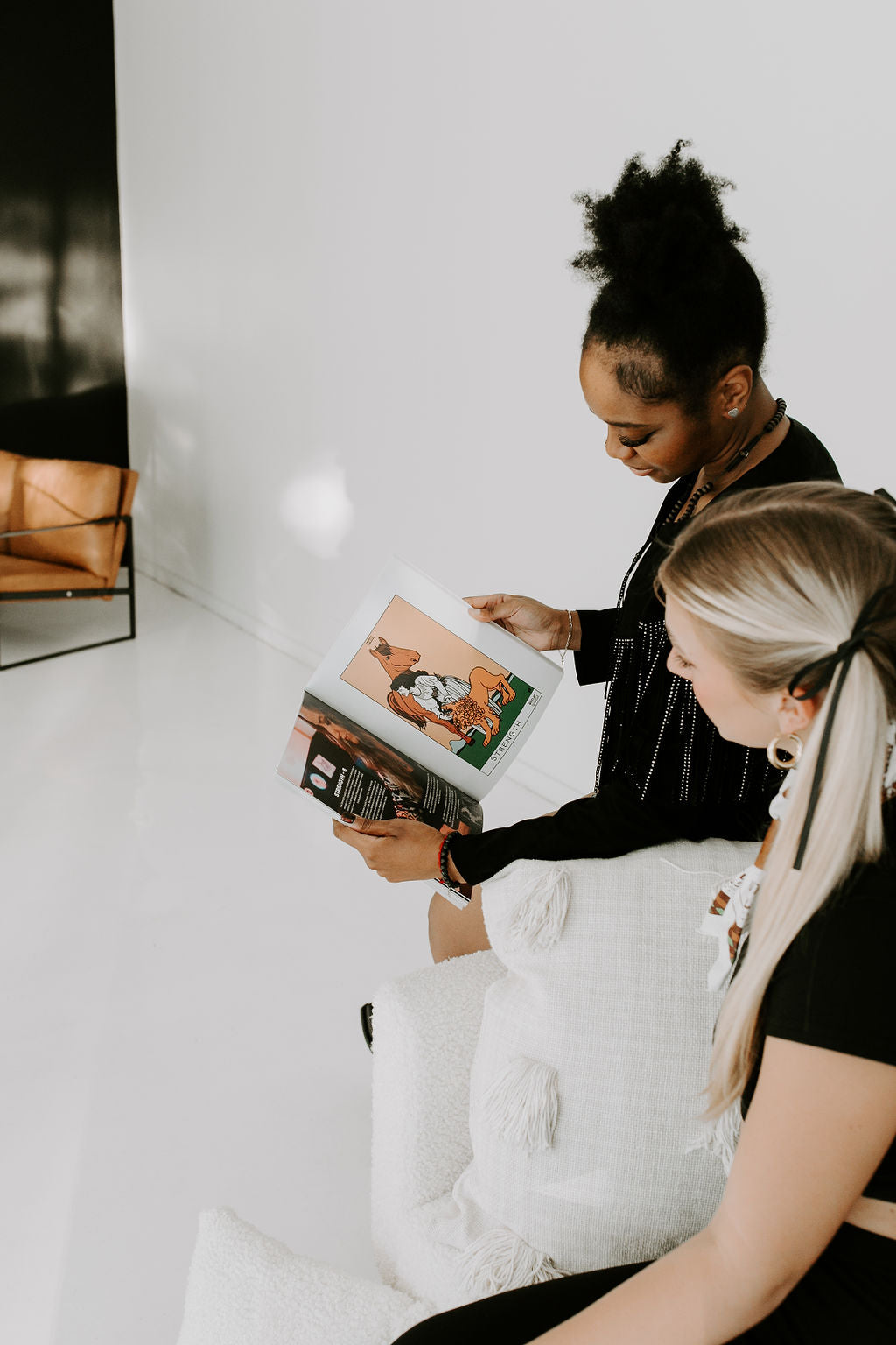 Women holding and looking at The Outlaw Oracle Honky Tonk Tarot Colorin' Book