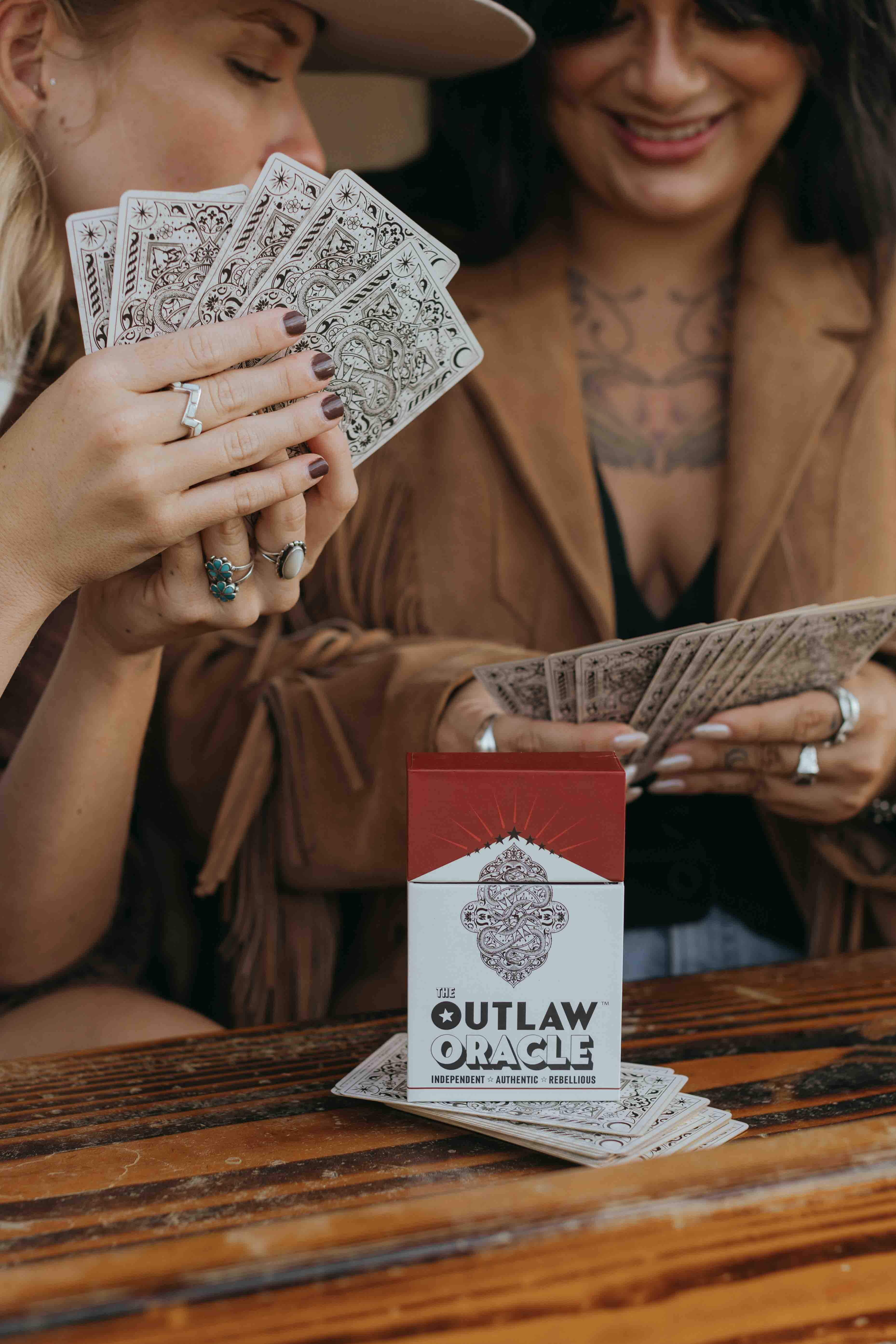 The Outlaw Oracle cards being shuffled and held, showing card stock quality and finish