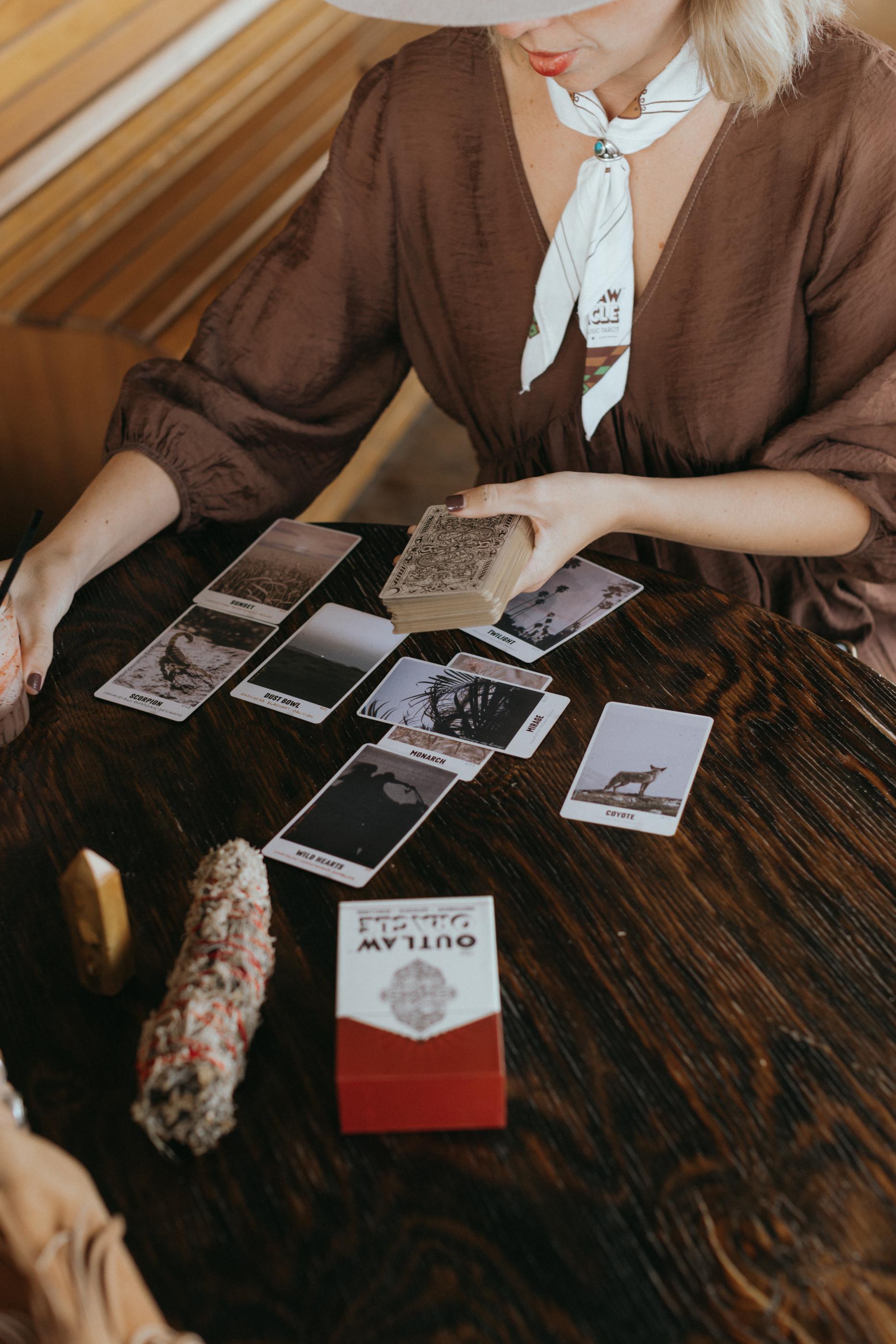 Woman laying out cards from The Outlaw Oracle Card Deck